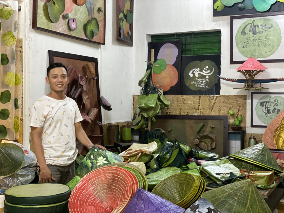 Hoạ sỹ Nguyễn Thanh Thảo cùng các sản phẩm sáng tạo từ sen. (Ảnh: Mai Trang/TTXVN)