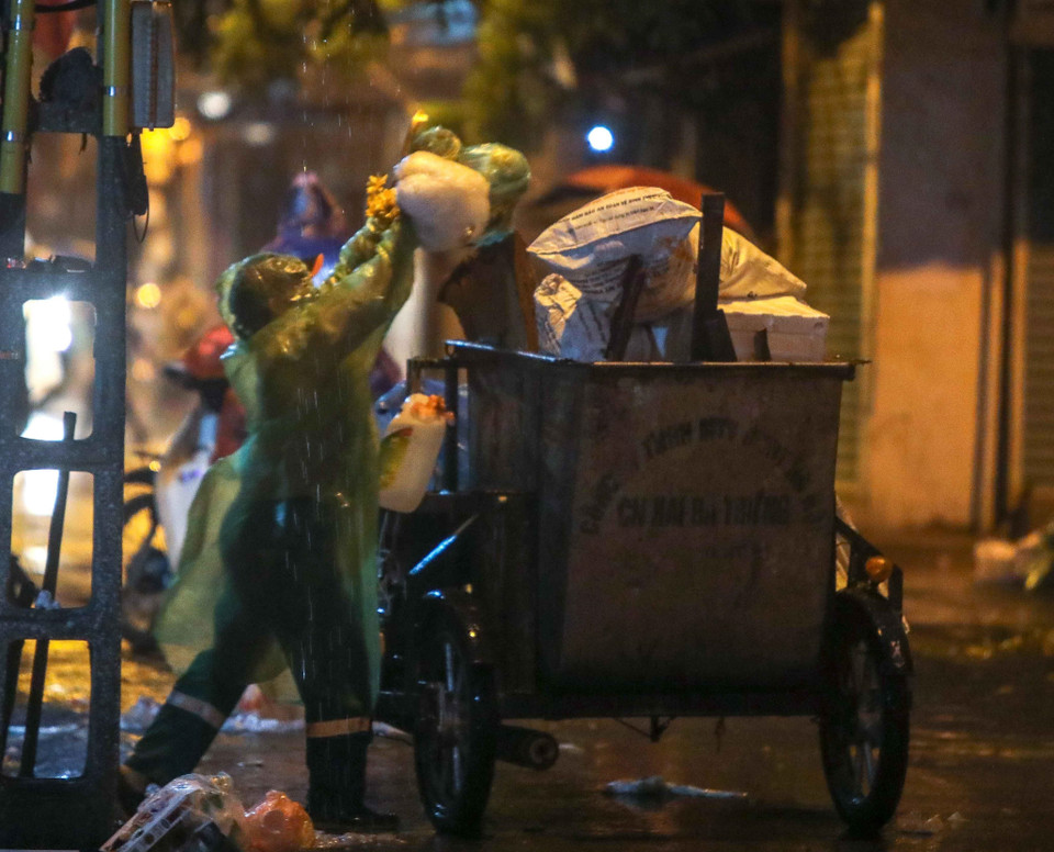 Bất kể mưa gió, việc thu gom rác thải của những người làm công tác vệ sinh môi trường vẫn diễn ra bình thường. (Ảnh: Thanh Tùng/TTXVN)