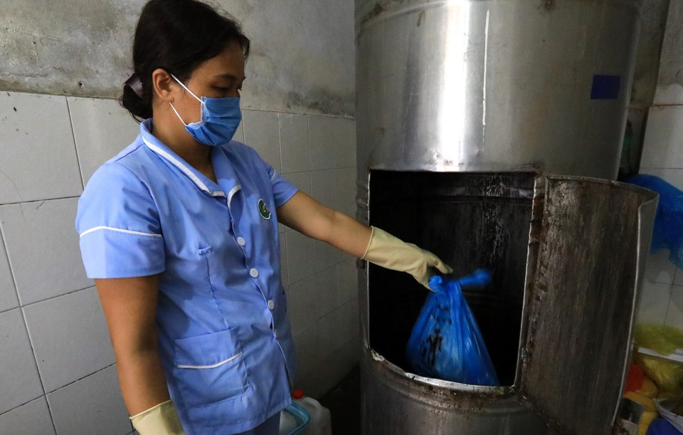 Nhân viên y tế bệnh viện Thanh Nhàn chuyển chất thải vào đường ống đưa đến nơi quy định. (Ảnh: Thành Đạt/TTXVN)