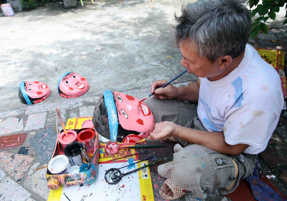 Mặt nạ được các nghệ nhân sơn thủ công tỉ mỉ. (Ảnh: Phạm Kiên/TTXVN)