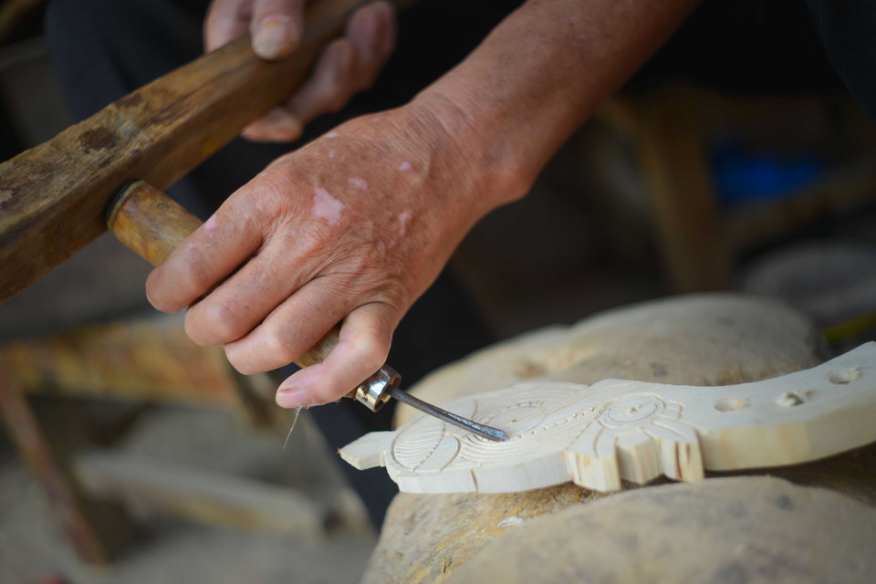 Các họa tiết trên cần đàn được chế tác hoàn toàn thủ công, tỉ mỉ từng chi tiết. (Ảnh: Việt Sơn/TTXVN)