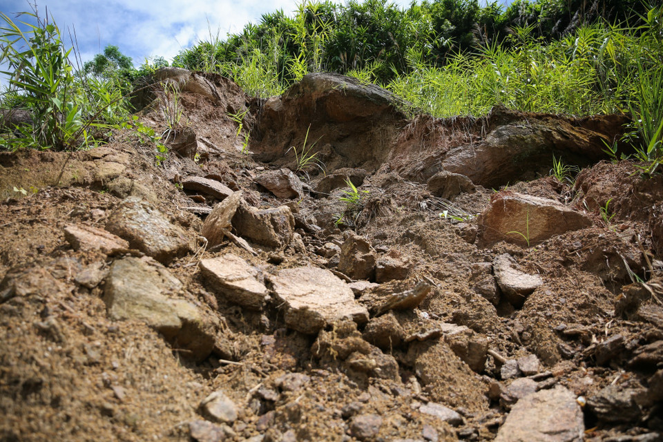Trên cao, nhiều khối đất đá khác cũng đang chực chờ rơi xuống trên tuyến Quốc lộ 16 gây mất an toàn cho người đi đường. (Ảnh: Bích Huệ/TTXVN)