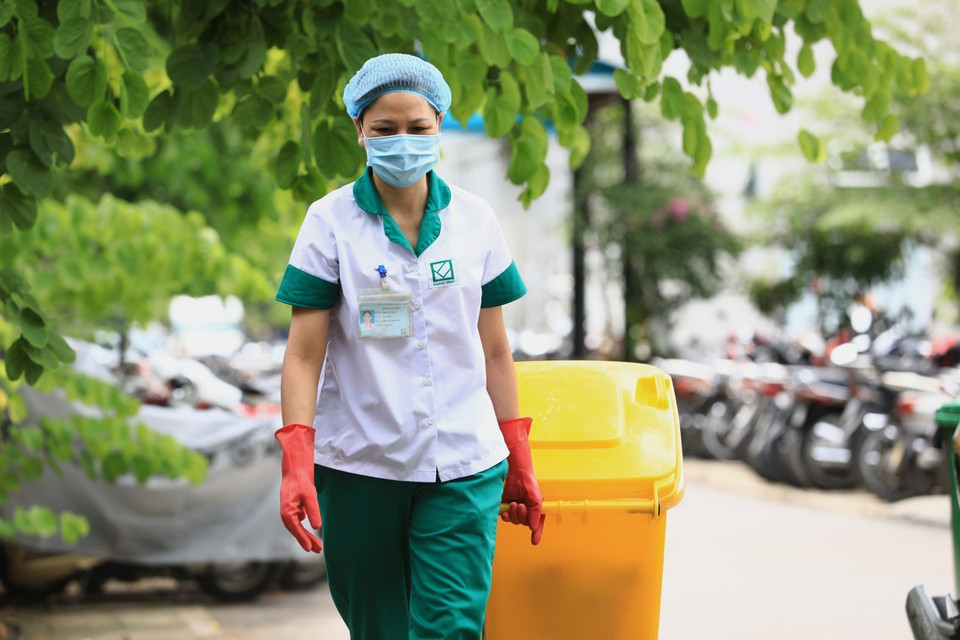 Một ngày 2 ca sáng và chiều nhân viên vệ sinh vận chuyển chất thải đã phân loại xuống nhà lưu chứa của Bệnh viện. (Ảnh: Thành Đạt/TTXVN)