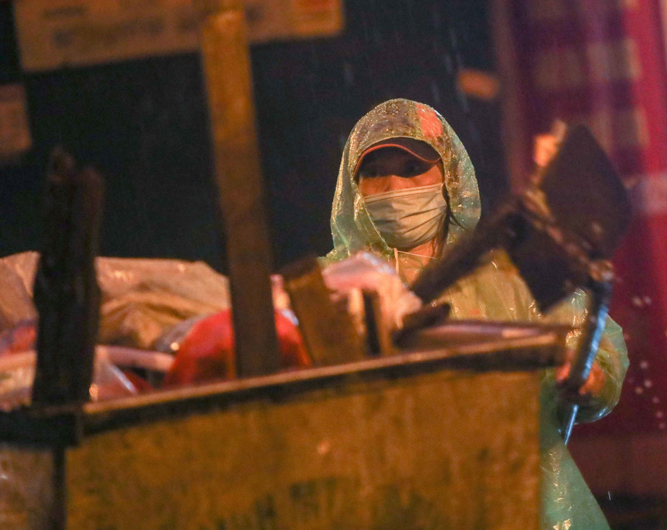 Bất kể mưa gió, việc thu gom rác thải của những người làm công tác vệ sinh môi trường vẫn diễn ra bình thường. (Ảnh: Thanh Tùng/TTXVN)