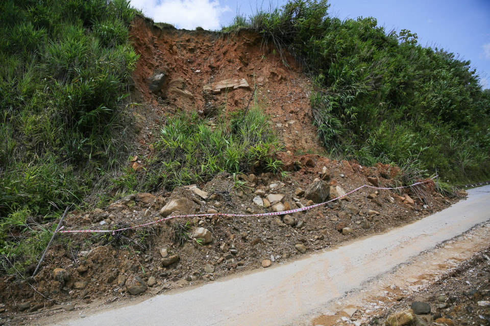 Trên cao, nhiều khối đất đá khác cũng đang chực chờ rơi xuống trên tuyến Quốc lộ 16 gây mất an toàn cho người đi đường. (Ảnh: Bích Huệ/TTXVN)