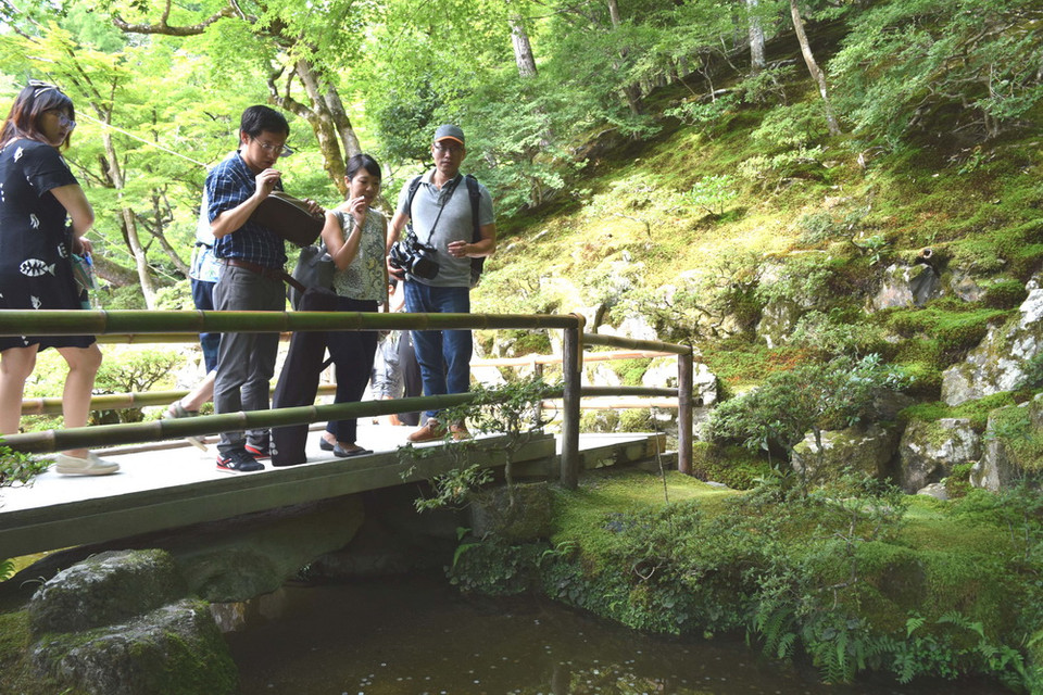 Du khách ném tiền cầu may xuống dòng suối ở chùa Bạc. (Ảnh: Nguyễn Tuyến/Vietnam+)