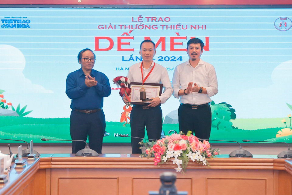 Nhà thơ Trần Đăng Khoa và Tổng Biên tập Báo Thể thao và Văn hóa Lê Xuân Thành trao giải Hiệp sỹ Dế Mèn cho đại diện tác giả Lý Lan (NXB trẻ) với tác phẩm “Tự truyện một con heo." (Ảnh: Minh Quyết/TTXVN)