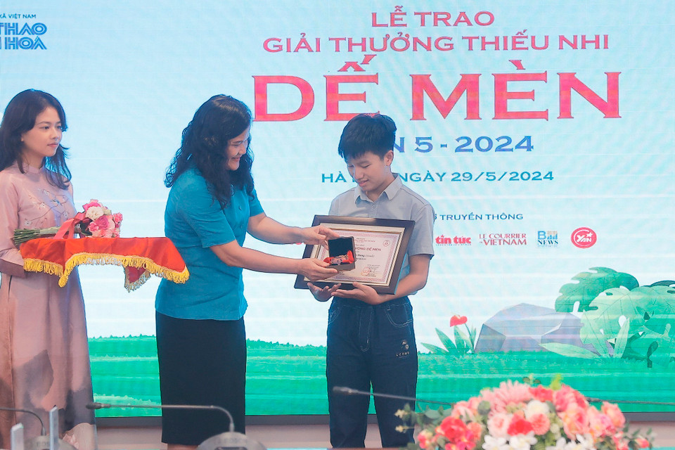 Phó Tổng Giám đốc TTXVN Nguyễn Thị Sự trao giải Khát vọng Dế Mèn cho tác giả có tác phẩm đoạt giải. (Ảnh: Minh Quyết/TTXVN)