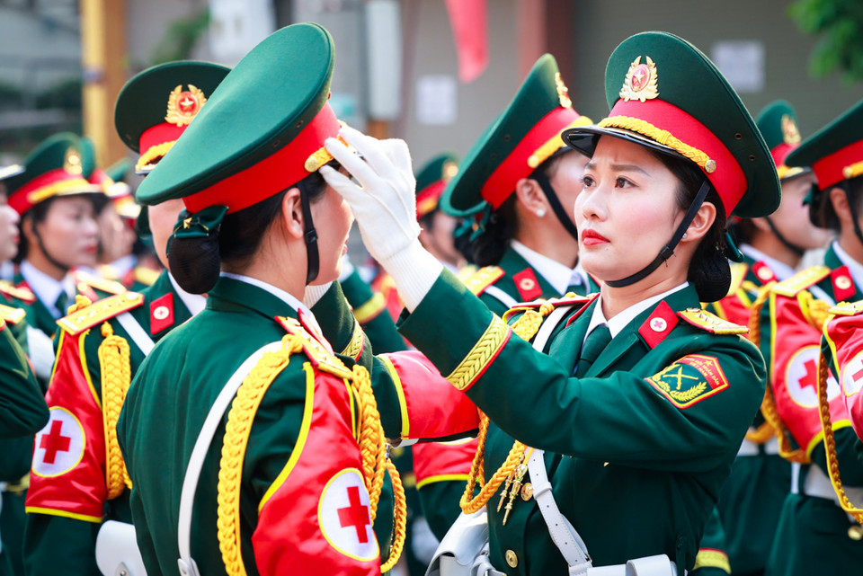 Hình ảnh hai nữ chiến sỹ chỉnh đốn quân phục trong buổi tổng duyệt. (Ảnh: Hải An/Vietnam+)