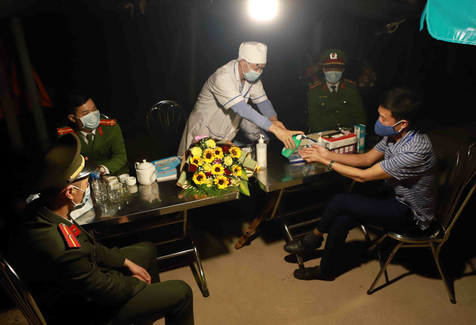 Bí thư xã Sơn Lôi Nguyễn Như Tâm (đầu tiên bên phải) thăm hỏi động viên cán bộ tại chốt trực số 6 xã Sơn Lôi. (Ảnh: Hoàng Hùng/TTXVN)