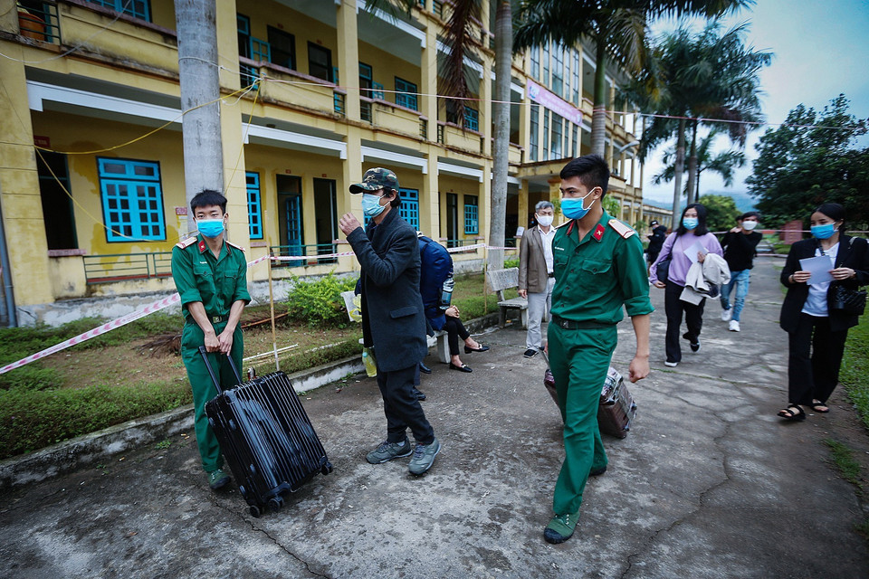 Các chiến sỹ hỗ trợ vận chuyển hành lý tư trang cho các công dân ra xe về với gia đình. (Ảnh: Trọng Đạt/TTXVN)