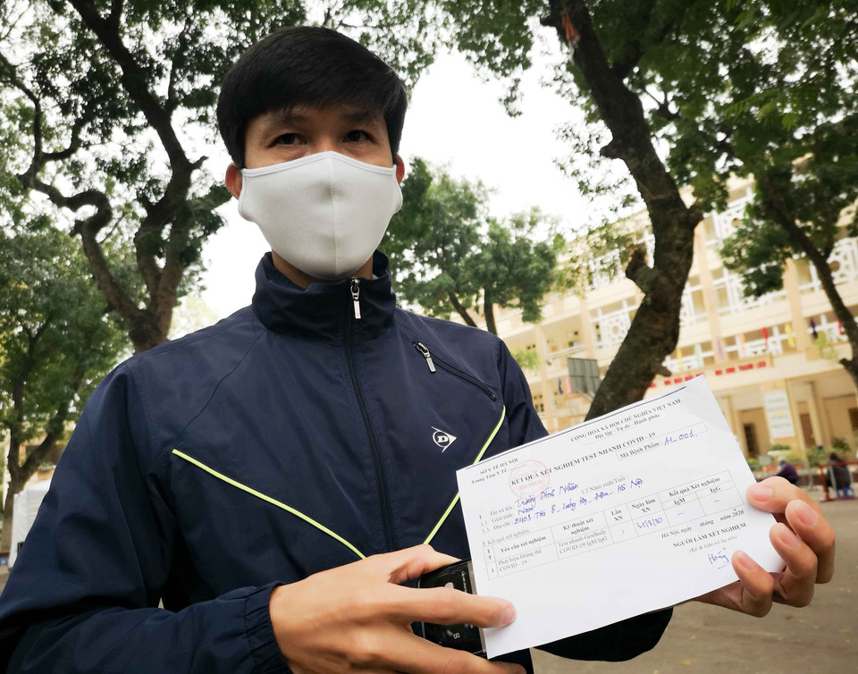 Người dân nhận kết quả xét nghiệm tại điểm test nhanh ở trường THCS Đống Đa (Hà Nội). (Ảnh: Thanh Tùng/TTXVN)