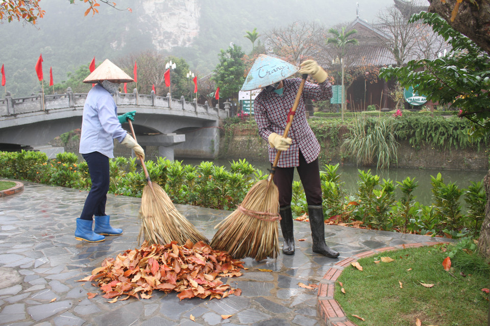 Dọn vệ sinh môi trường sau khi tạm thời dừng đón khách tại Khu du lịch sinh thái Tràng An, tỉnh Ninh Bình. (Ảnh: Thùy Dung/TTXVN)