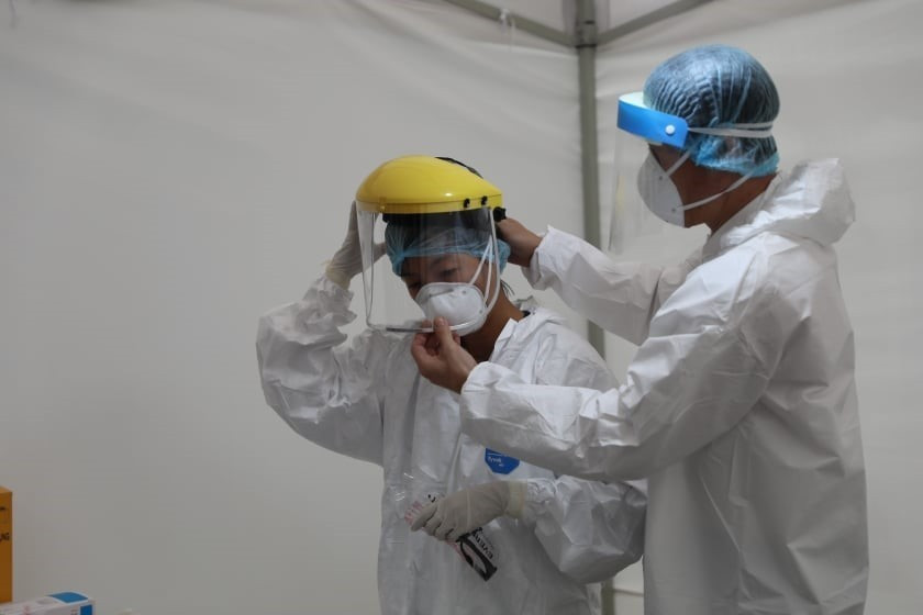 Tổ công tác chuẩn bị các thiết bị cơ sở vật chất phục vụ test nhanh có kết quả trong 10 phút tại điểm trường THCS Đống Đa (Hà Nội) sáng 31/3/2020. (Ảnh: Thanh Tùng/TTXVN)