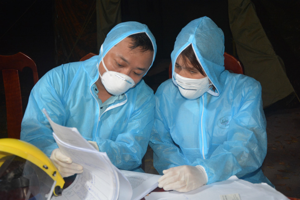 Trong ảnh: Các y bác sỹ ở điểm chốt dịch Ô Hòa Phước (huyện Hòa Vang) kiểm tra danh sách hành khách trong đêm. (Ảnh: Văn Dũng/TTXVN)