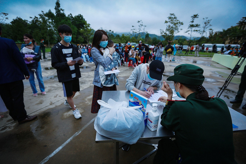 Các công dân ký nhận giấy chứng nhận hoàn thành thời gian cách lý theo dõi COVID-19. (Ảnh: Trọng Đạt/TTXVN)