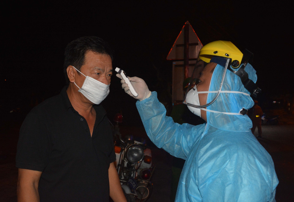 Trong ảnh: Y bác sỹ tại chốt kiểm dịch COVID-19 Ô Hòa Phước (huyện Hòa Vang) kiểm tra thân nhiệt của hành khách. (Ảnh: Văn Dũng/TTXVN)