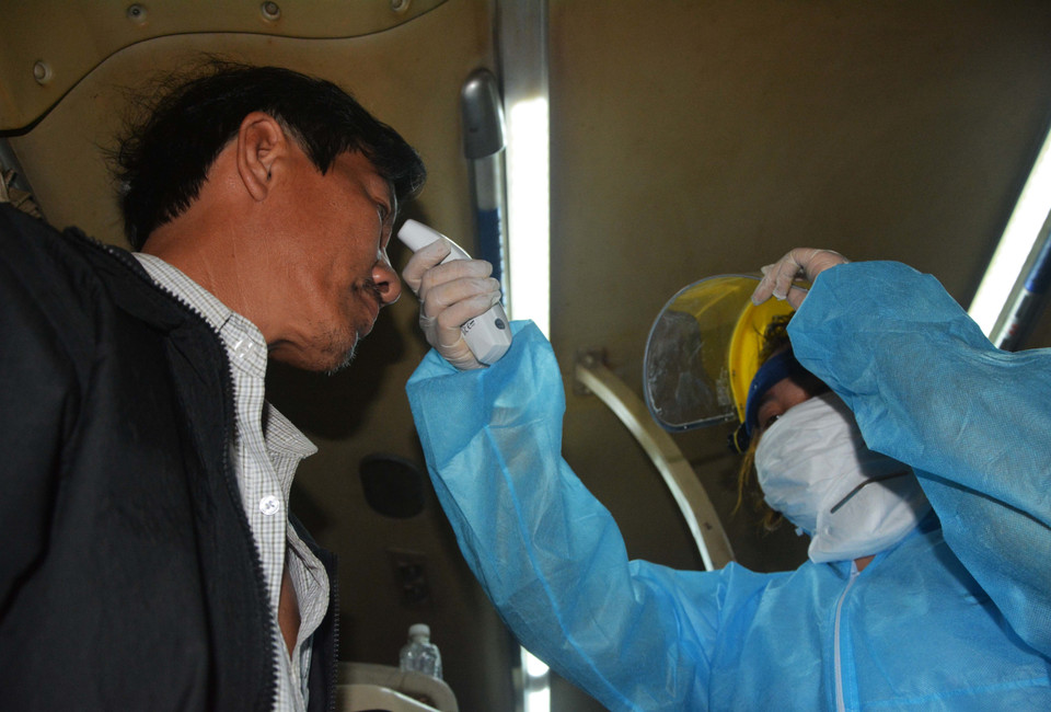 Trong ảnh: Y bác sỹ tại chốt kiểm dịch COVID-19 Ô Hòa Phước (huyện Hòa Vang) kiểm tra thân nhiệt của hành khách. (Ảnh: Văn Dũng/TTXVN)