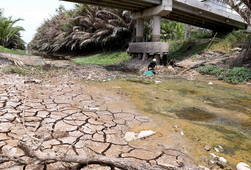 Nông dân Nguyễn Văn Thuận ở xã Long Hòa, thị xã Gò Công, bơm những giọt nước cuối cùng trong kênh N14 để tưới rau màu của gia đình. (Ảnh: Vũ Sinh/TTXVN)