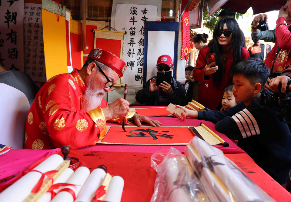 Văn Miếu-Quốc Tử Giám là địa điểm mỗi dịp Tết đến, Xuân về, người dân lại tới xin chữ đầu năm. Đó là nét văn hoá truyền thống tốt đẹp của người Việt, bắt nguồn từ sự hiếu học, trọng chữ và trọng tri thức. (Ảnh: Phạm Kiên/TTXVN)