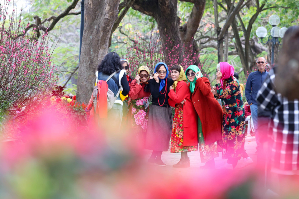 Không khí phấn khởi, vui tươi của người dân và du khách tham quan, chụp ảnh bên hồ Hoàn Kiếm trong ngày 29 Tết. (Ảnh: Thanh Tùng/TTXVN)