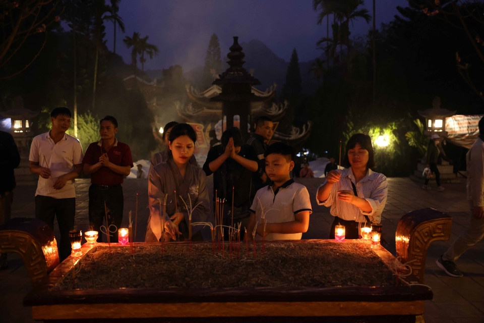 Người dân và du khách dâng hương trước giờ khai hội chùa Hương. (Ảnh: Thanh Tùng/TTXVN)