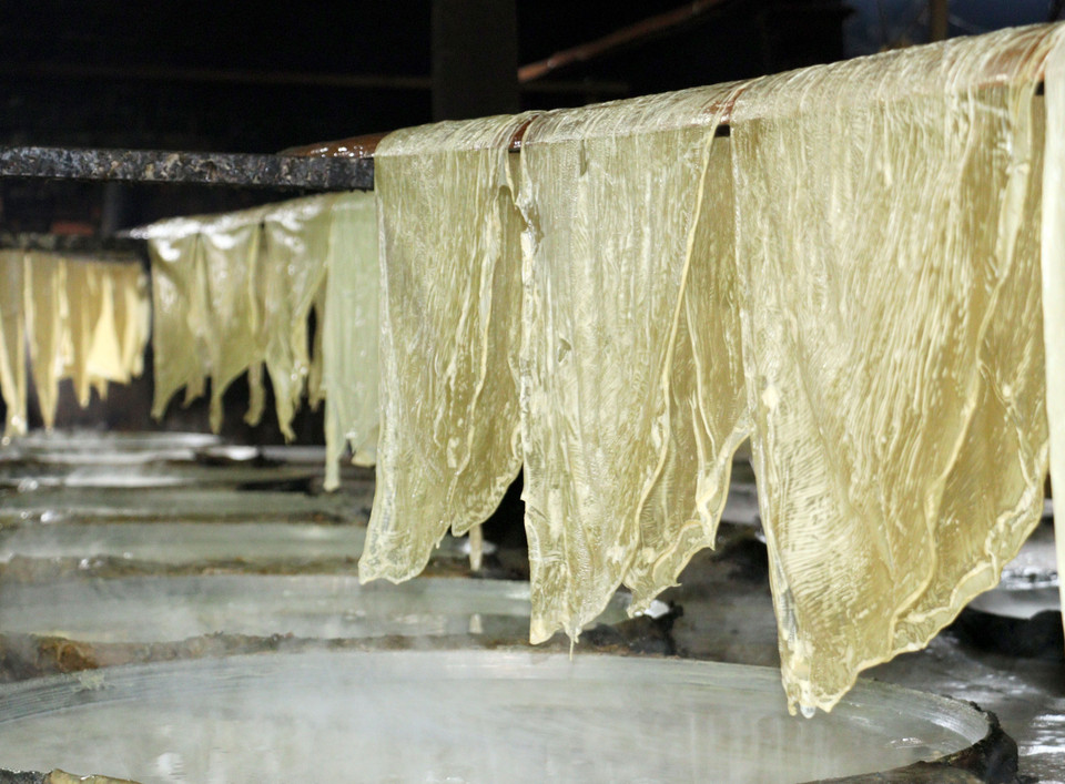 Các lá tàu hũ được hong khô bằng hơi nóng từ các chảo đậu nành. (Ảnh: Lê Thúy Hằng/TTXVN)