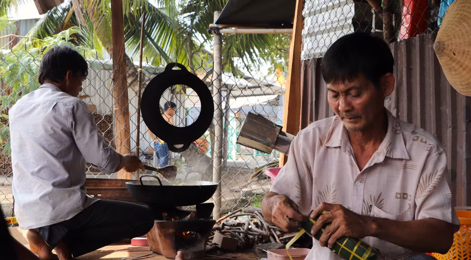 Mỗi người một công đoạn, góp phần làm nên chiếc bánh thơm ngon. (Ảnh: Nguyễn Hằng/TTXVN)