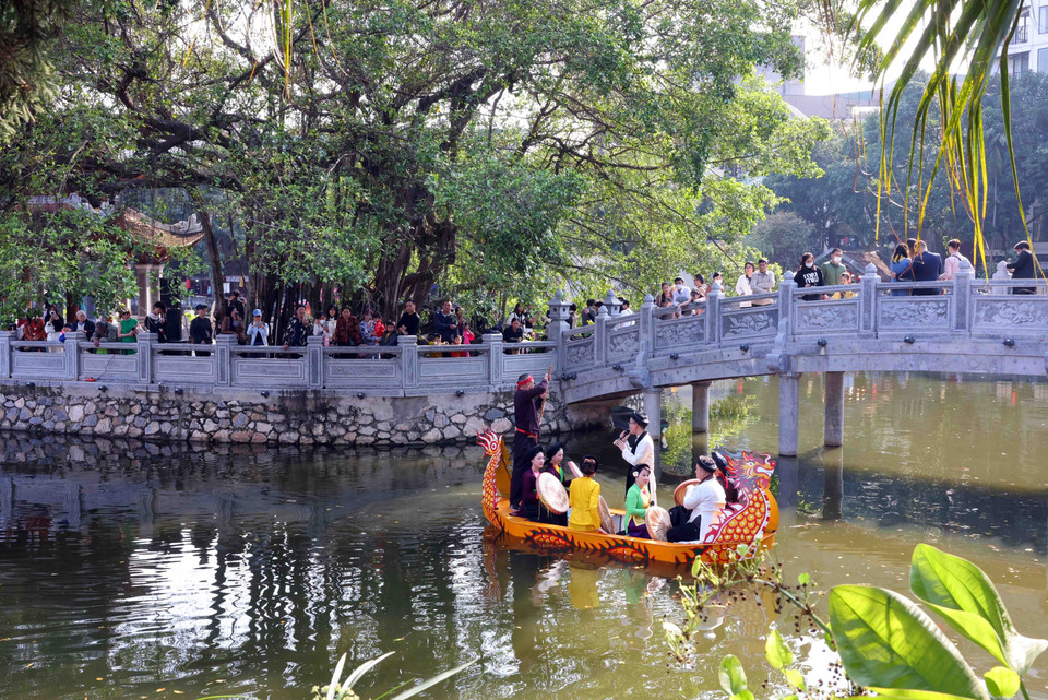 Người dân du Xuân tại Hồ Văn-Văn Miếu còn được thưởng thức các liền anh, liền chị biểu diễn hát quan họ. (Ảnh: Phạm Kiên/TTXVN)