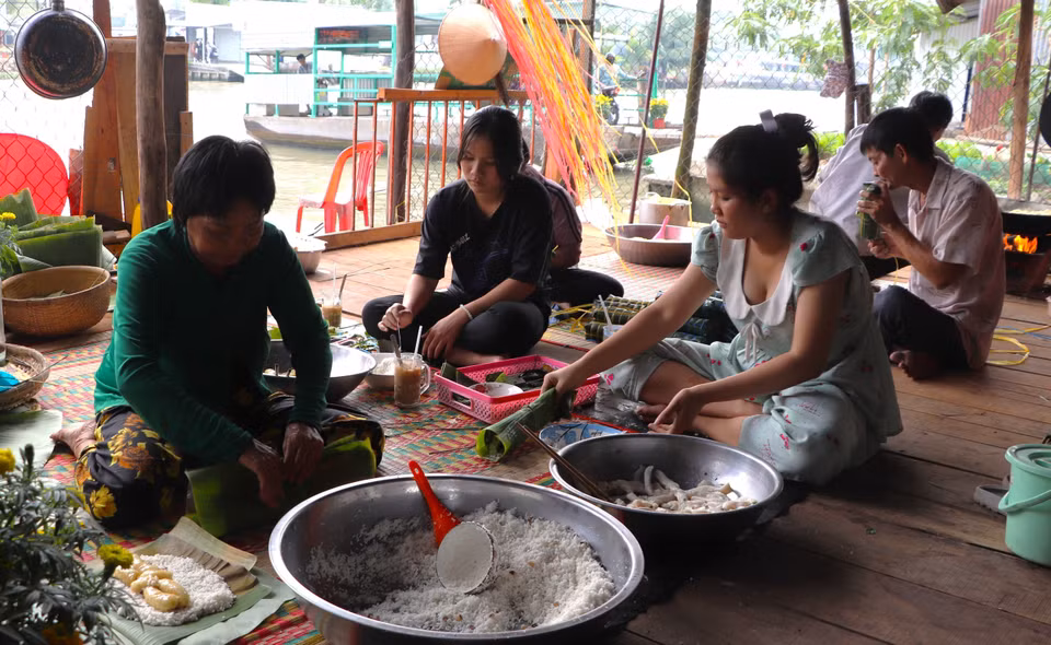Với nhiều người, gói bánh Tét là cách gửi gắm thông điệp cho thế hệ sau lưu giữ truyền thống của ngày Tết sum vầy. (Ảnh: Nguyễn Hằng/TTXVN)