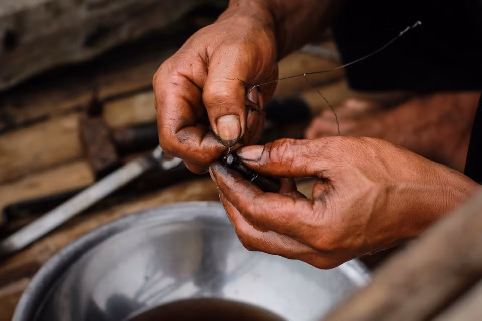 Người ngư dân khéo léo sửa chữa con thuyền tự tay mình đóng. Biển to sóng lớn, tàu thuyền nhỏ bé lại thô sơ, việc hỏng hóc xảy ra thường xuyên, việc sửa chữa cũng trở nên thành thạo và quen thuộc hơn. (Ảnh: Thanh Dung/Vietnam+)