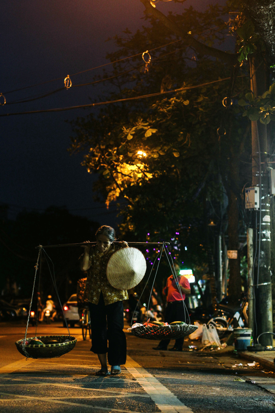 Dáng vẻ khắc khổ của người phụ nữ cả đời làm nghề bán hàng rong ở Hà Nội. (Ảnh: Thanh Dung/Vietnam+)