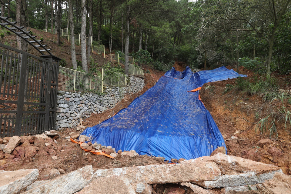 Vị trí xói lở từ chân đồi, đất đá trôi xuống khiến hàng loạt ôtô mắc kẹt. (Ảnh: Minh Quyết/TTXVN)