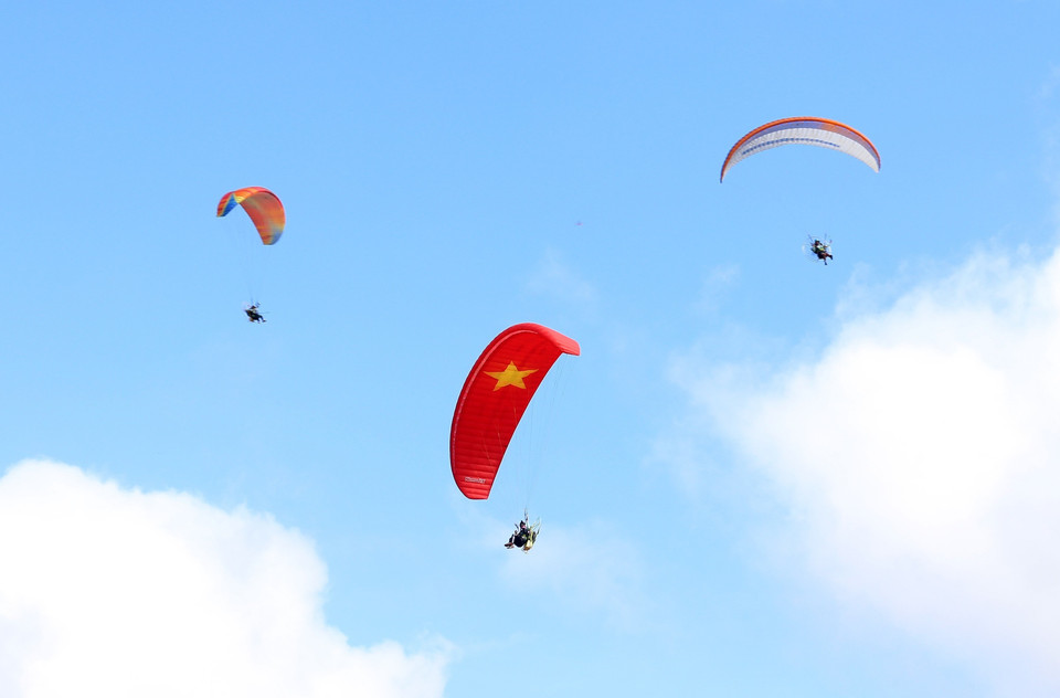 Các vận động viên trình diễn dù lượn với nội dung "Giữa mùa vàng Bát Xát." (Ảnh: Quốc Khánh/TTXVN)