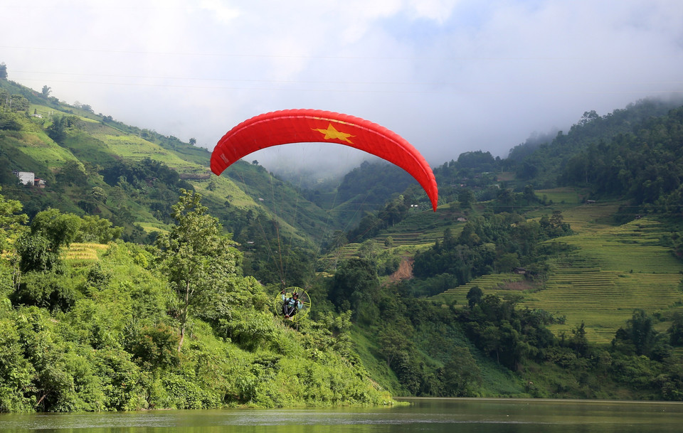 Các vận động viên trình diễn dù lượn với nội dung "Giữa mùa vàng Bát Xát." (Ảnh: Quốc Khánh/TTXVN)