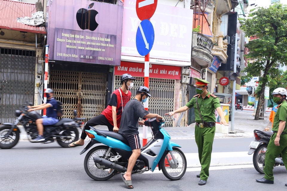 Công an phường Bạch Mai (quận Hai Bà Trưng) kiểm tra những người ra đường, sáng 26/7. (Ảnh: Hoàng Hiếu/TTXVN)