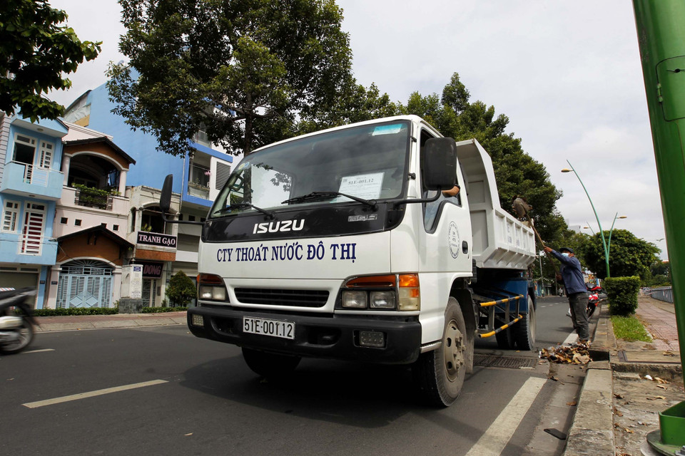 Người lao động công ty thoát nước đô thị vẫn làm công việc thu gôm rác, khai thông cống rãnh thường xuyên, kể cả những ngày giãn cách xã hội. (Ảnh: Thanh Vũ/TTXVN)