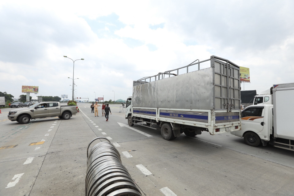 Lực lượng chức năng hướng dẫn các phương tiện quay đầu tại trạm thu phí Pháp Vân-Cầu Giẽ khi thực hiện Chỉ thị 17 của UBND thành phố. (Ảnh: Minh Quyết/TTXVN)