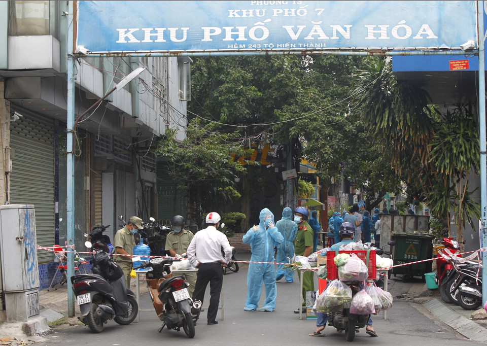 Trong những ngày giãn cách xã hội vẫn có những lúc tập trung cao điểm các lực lượng chức năng (Quận 10) để khoanh vùng cách ly, điều tra dịch tể, lấy mẫu xét nghiệm cộng đồng sau khi phát hiện ca nhiễm COVID-19. (Ảnh: Thanh Vũ/TTXVN)
