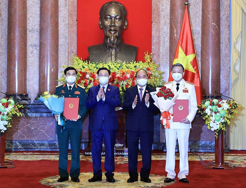 Chủ tịch nước Nguyễn Xuân Phúc trao Quyết định, Chủ tịch Quốc hội Vương Đình Huệ tặng hoa cho Bộ trưởng Bộ Công An, Đại tướng Tô Lâm và Bộ trưởng Bộ Quốc phòng, Đại tướng Phan Văn Giang. (Ảnh: Thống Nhất/TTXVN)