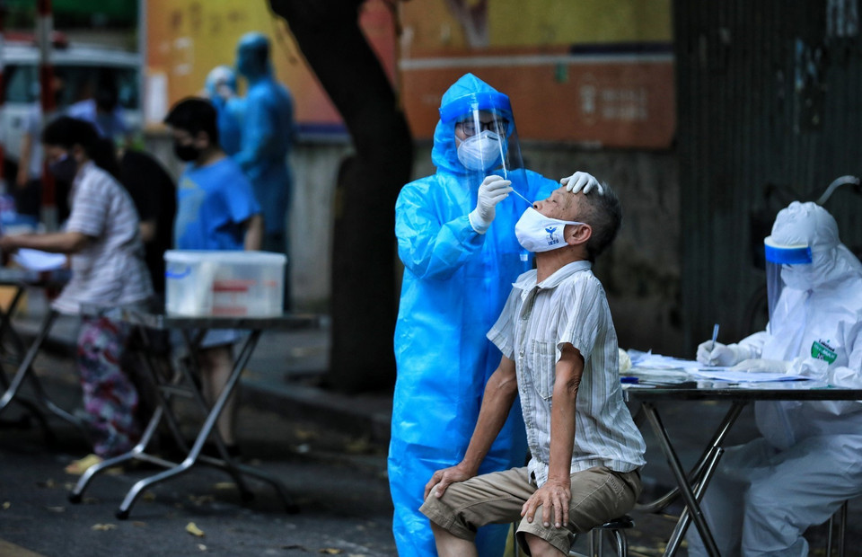 Lực lượng y tế quận Hoàn Kiếm tiến hành lấy mẫu xét nghiệm cho gần 30 hộ dân có liên quan đến bệnh nhân P.T.T.T, nữ, sinh năm 1997, địa chỉ 39 Hàng Bài có kết quả dương tính với SARS-CoV-2. (Ảnh: Thành Đạt/TTXVN)