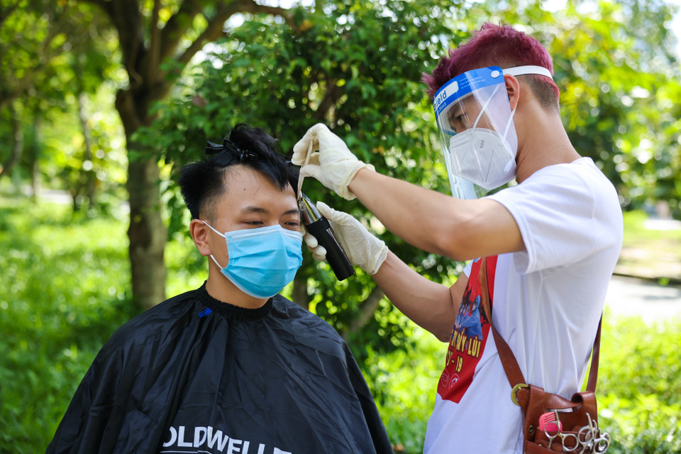 Các văn nghệ sỹ chung tay mang lại mái tóc mới gọn gàng, đẹp đẽ cho các nhân viên y tế. (Nguồn: Vietnam+)