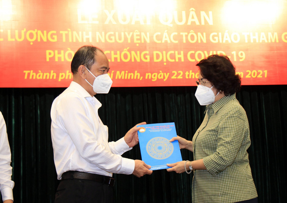Bà Tô Thị Bích Châu, Chủ tịch Ủy ban Mặt trận Tổ quốc Việt Nam Thành phố Hồ Chí Minh trao danh sách tình nguyện viên tôn giáo cho đại diện lãnh đạo Sở Y tế Thành phố Hồ Chí Minh. (Ảnh: Xuân Khu/TTXVN)