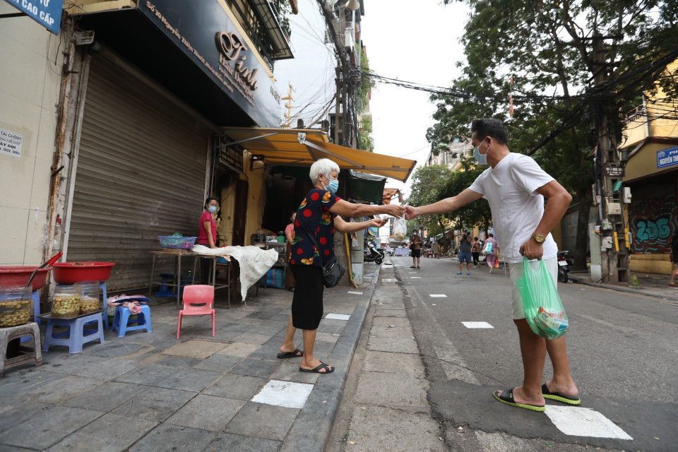 Người dân giữ khoảng cách khi mua hàng tại khu mua sắm hàng thiết yếu trên phố Nguyễn Thiện Thuật (ảnh chụp sáng 26/7). (Ảnh: Minh Quyết/TTXVN)