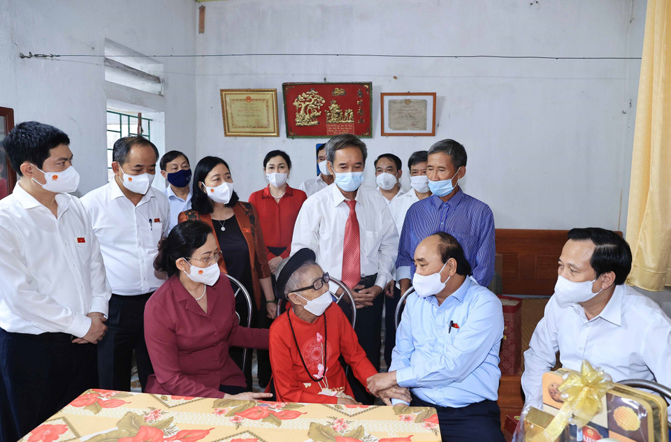 Chủ tịch nước Nguyễn Xuân Phúc đến thăm hỏi và tặng quà cho Mẹ Việt Nam Anh hùng Nguyễn Thị Mờn. (Ảnh: Thống Nhất/TTXVN)