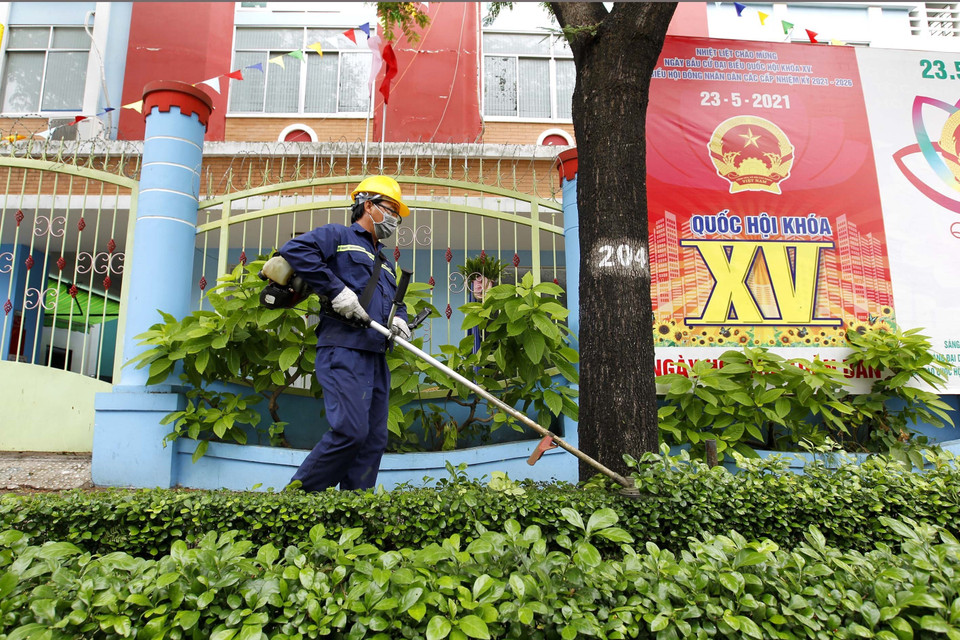 Trong những ngày thành phố giãn cách xã hội, công nhân Công ty dịch vụ công ích Quận 3 vẫn phải đảm bảo chăm sóc, tưới cây tại các khuôn viên trên các tuyến đường của quận. (Ảnh: Thanh Vũ/TTXVN)