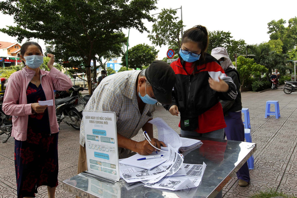 Người dân khai báo y tế để đi mua hàng thiết yếu tại siêu thị. (Ảnh: Thanh Vũ/TTXVN)