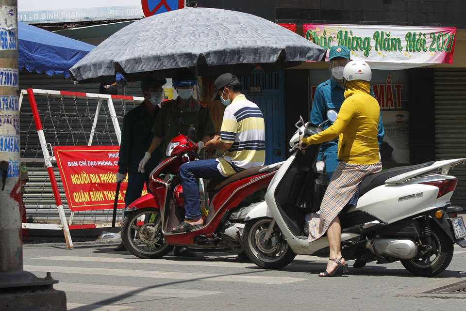 Lực lượng công an và dân quân phường 11, quận Bình Thạnh vẫn trực kiểm soát tại chốt ngã tư đường Lê Quang Định-Phan Văn Đậu (quận Bình Thạnh). (Ảnh: Thanh Vũ/TTXVN)