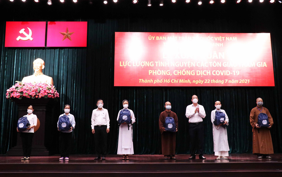 Sáng 22/7/2021, tại Hội trường Thành ủy Thành phố Hồ Chí Minh, Ủy ban Mặt trận Tổ quốc Việt Nam Thành phố Hồ Chí Minh trang trọng tổ chức Lễ xuất quân lực lượng tình nguyện tôn giáo đợt đầu tiên tham gia hỗ trợ các bệnh viện dã chiến, bệnh viện hồi sức COVID-19 trên địa bàn Thành phố. Trong ảnh: Lãnh đạo Thành phố trao tượng trương ba lô, vật dụng cá nhân cho đại diện các tình nguyện viên tôn giáo. (Ảnh: Xuân Khu/TTXVN)