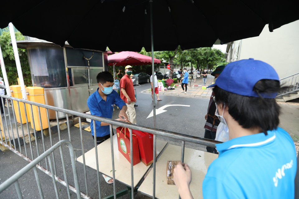 Người dân đến tiếp tế lương thực, nhu yếu phẩm cần thiết cho người bên trong khu cách ly tại chung cư Ecohome 2 (ảnh chụp chiều 23/7/2021). (Ảnh: Minh Quyết/TTXVN)